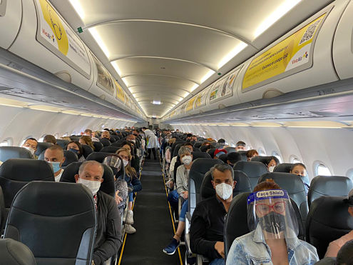 aeroplane with passengers following social distancing and wearing masks in colombia following reopening of international flights post coronavirus covid 19